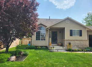 View of front of home featuring a front lawn, fence, and brick siding