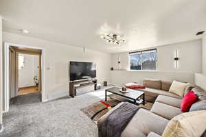 Living area featuring a textured ceiling, carpet floors, and visible vents