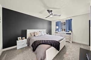 Bedroom featuring carpet floors, ceiling fan, baseboards, and a textured ceiling