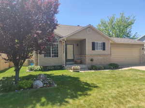 View of front facade featuring brick siding, concrete driveway, a front yard, entry steps, and a garage