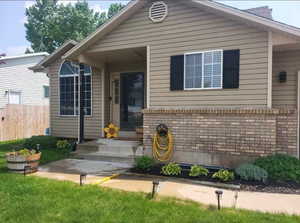 Bungalow-style house featuring brick siding and fence