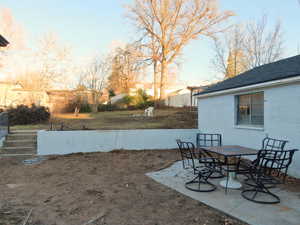 View of yard featuring outdoor dining space and a patio