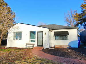 Bungalow-style home featuring entry steps, roof with shingles, and stucco siding