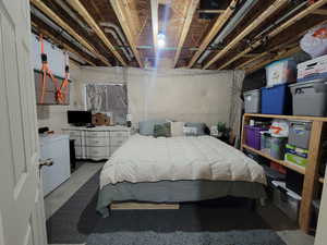 Bedroom featuring concrete floors and fridge