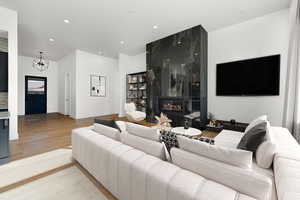 Living area with a large fireplace, recessed lighting, and light wood finished floors