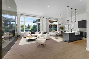 Living area with light wood-style floors, recessed lighting, and a large fireplace