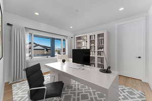 Office featuring light wood-type flooring and recessed lighting