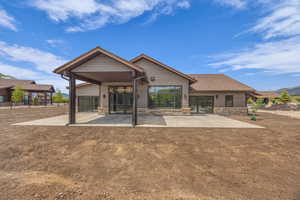 Rear view of property with a patio area and stone siding