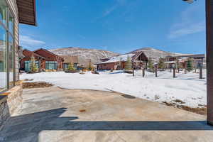 Yard covered in snow featuring fence and a mountain view