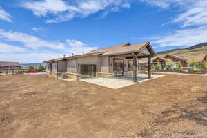 Back of house featuring a patio, stone siding, a mountain view, and central AC unit