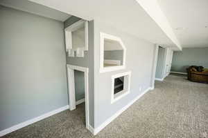 Corridor with baseboards and carpet flooring