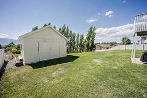 View of yard with an outbuilding, a shed, and a fenced backyard