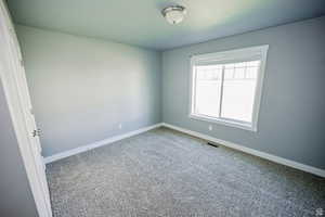 Unfurnished room featuring visible vents and baseboards