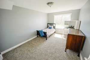 Bedroom with light colored carpet, visible vents, and baseboards