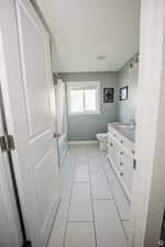 Full bath featuring visible vents, toilet, washtub / shower combination, vanity, and baseboards