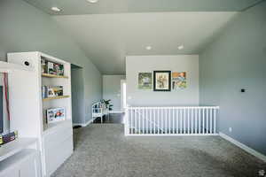 Interior space featuring carpet, vaulted ceiling, and baseboards