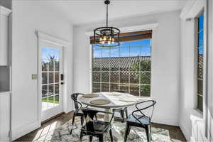 Dining room with dark wood-style floors, a notable chandelier, and baseboards