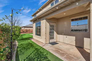 Property entrance featuring a yard, stucco siding, fence, and a patio