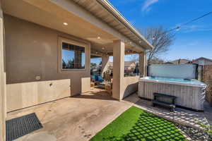 View of patio / terrace with a hot tub and fence