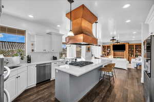 Kitchen featuring appliances with stainless steel finishes, pendant lighting, light countertops, and open floor plan