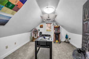 Recreation room with lofted ceiling, carpet floors, and baseboards