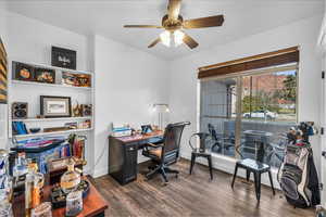 Office space featuring dark wood-style floors, baseboards, and a ceiling fan