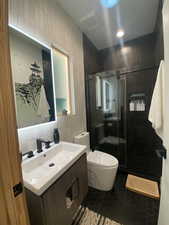 Full bath featuring a stall shower, toilet, tile patterned flooring, vanity, and tile walls