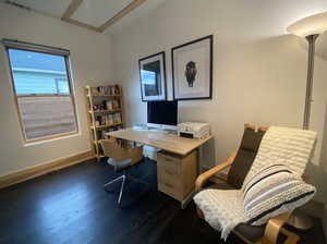 Home office featuring baseboards, visible vents, and dark wood finished floors