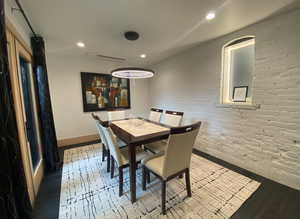 Dining room with recessed lighting, brick wall, wood finished floors, visible vents, and baseboards