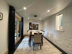 Dining space with brick wall, recessed lighting, and french doors