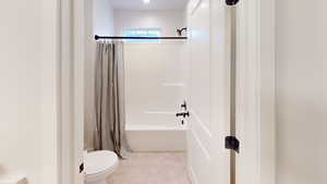 Bathroom with shower / bath combo with shower curtain and toilet