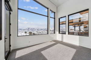 Carpeted spare room with a mountain view and baseboards