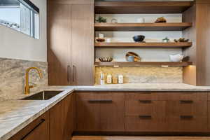 Bar featuring tasteful backsplash and a sink