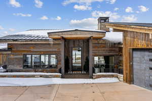 Snow covered property entrance with metal roof