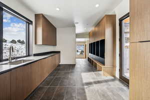 Interior space with baseboards, dark tile patterned floors, a sink, and recessed lighting