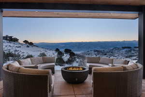 Snow covered patio with an outdoor living space with a fire pit and a mountain view