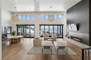 Living area featuring a chandelier, a glass covered fireplace, and wood finished floors