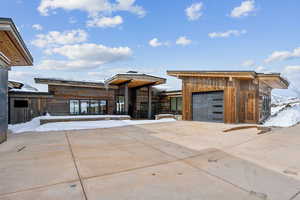 View of front of property featuring a garage and driveway