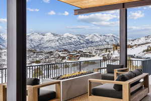 Snow covered back of property with a mountain view