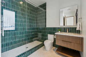 Full bathroom with visible vents, tile patterned flooring, vanity, a walk in shower, and tile walls