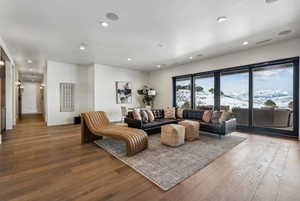 Living room with light wood-style flooring, visible vents, baseboards, and recessed lighting