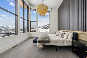 Bedroom with baseboards, visible vents, a chandelier, carpet floors, and a mountain view