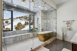 Bathroom featuring a freestanding tub, plenty of natural light, a mountain view, and tile patterned floors