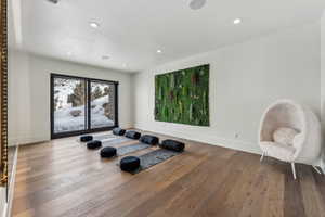 Workout room with baseboards, wood finished floors, and recessed lighting