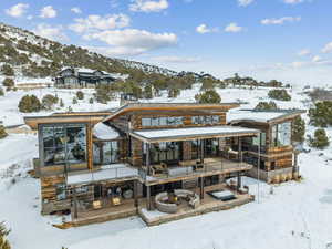 Snow covered back of property with a mountain view