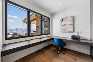 Office featuring a mountain view, dark wood-type flooring, built in desk, and recessed lighting