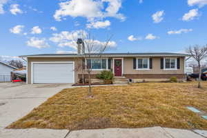 Ranch-style home with an attached garage, a front lawn, concrete driveway, and brick siding