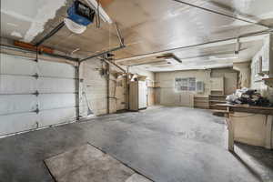 Garage with freestanding refrigerator and a garage door opener