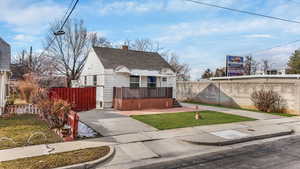 Bungalow-style house featuring a shingled roof, fence private yard, and a chimney