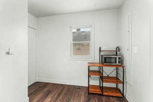 Office featuring visible vents, baseboards, and dark wood finished floors